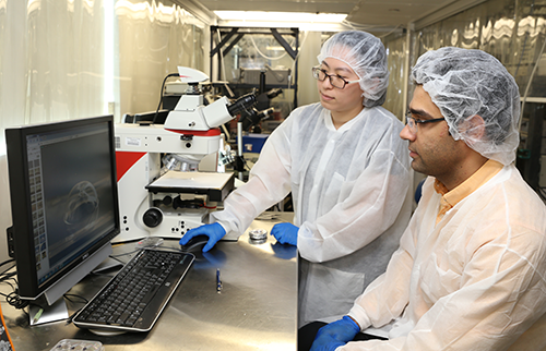 Graduate students Danmeng Wang (left) and Mohammad Asadian display a 3D prototype. Ultimately, the 2D and 3D architectures will complement each other in the IMU device.