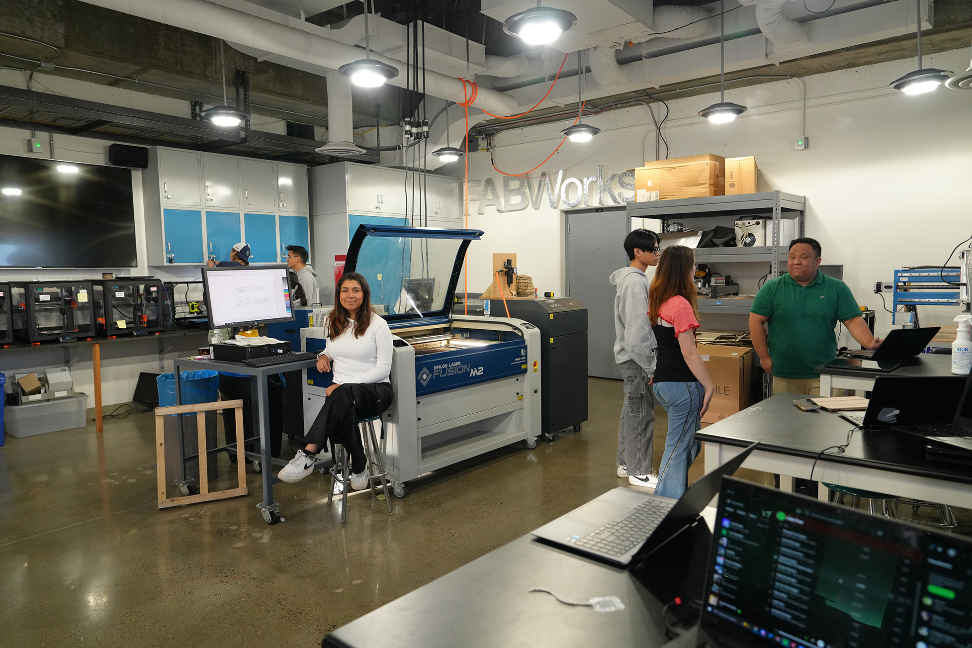  Daniela Yanira Campuzano (seated) credits the hands-on skills she learned as a FABWorks lab instructor with landing her an internship at Volvo this past summer.