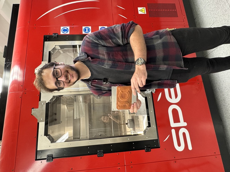 UCI doctoral student Michael Ross holds up a UCI metal plate made by the million-dollar cold spray machine behind him. (Photo: Natalie Tso/UCI) UCI doctoral student Michael Ross holds up a UCI metal plate made by the million-dollar cold spray machine behind him. (Photo: Natalie Tso/UCI)