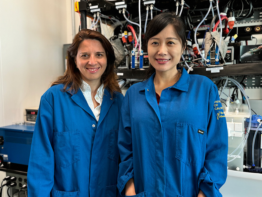 Iryna Zenyuk (left) and Mo Li in front of an electrolyzer at the National Fuel Cell Research Center at UC Irvine.