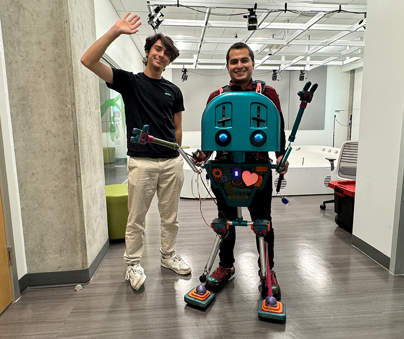 UCI computer science and engineering student Ervin Grimaldi ’25 and postdoctoral researcher Efraín Méndez with Jean Luc at the UCI Robot Ecology Lab 