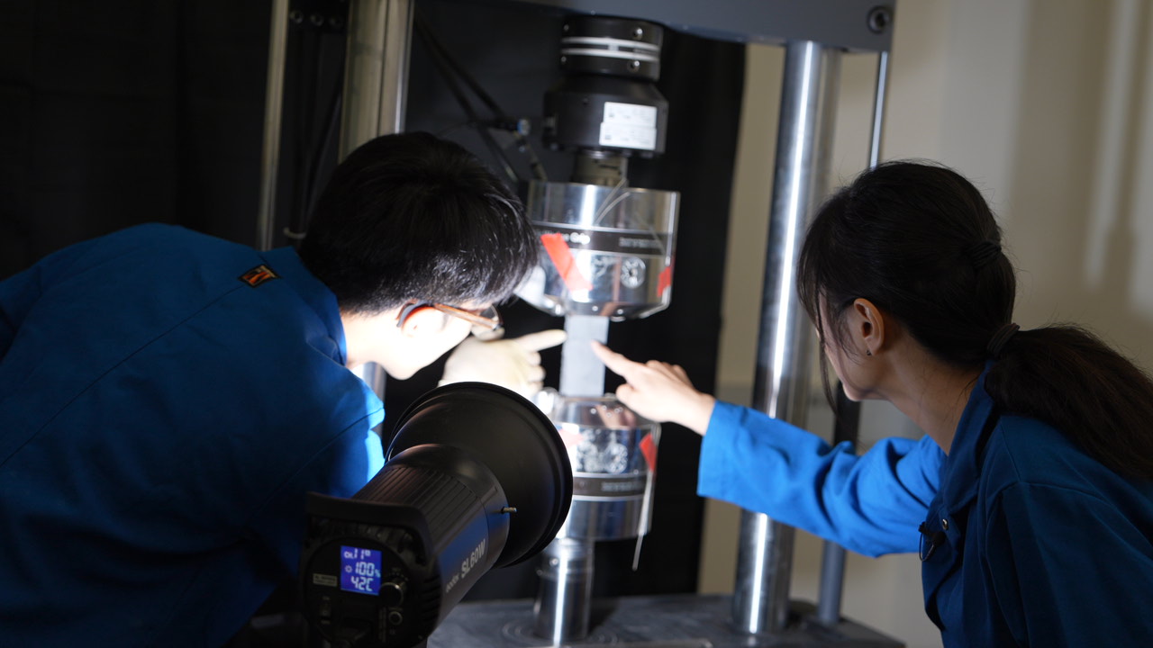 Two researchers in a laboratory inspecting equipment.