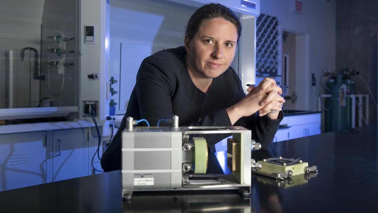Woman standing in lab behind device.